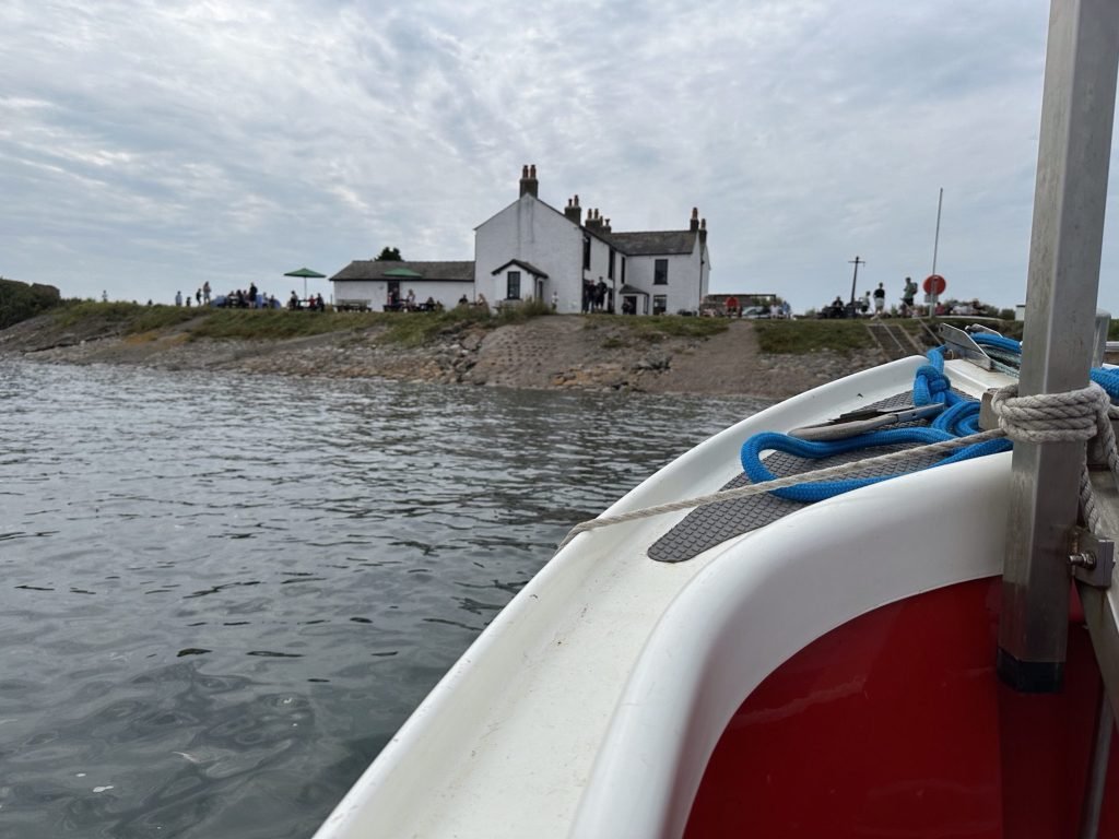 Wit huis op eiland gezien vanaf overzetbootje.