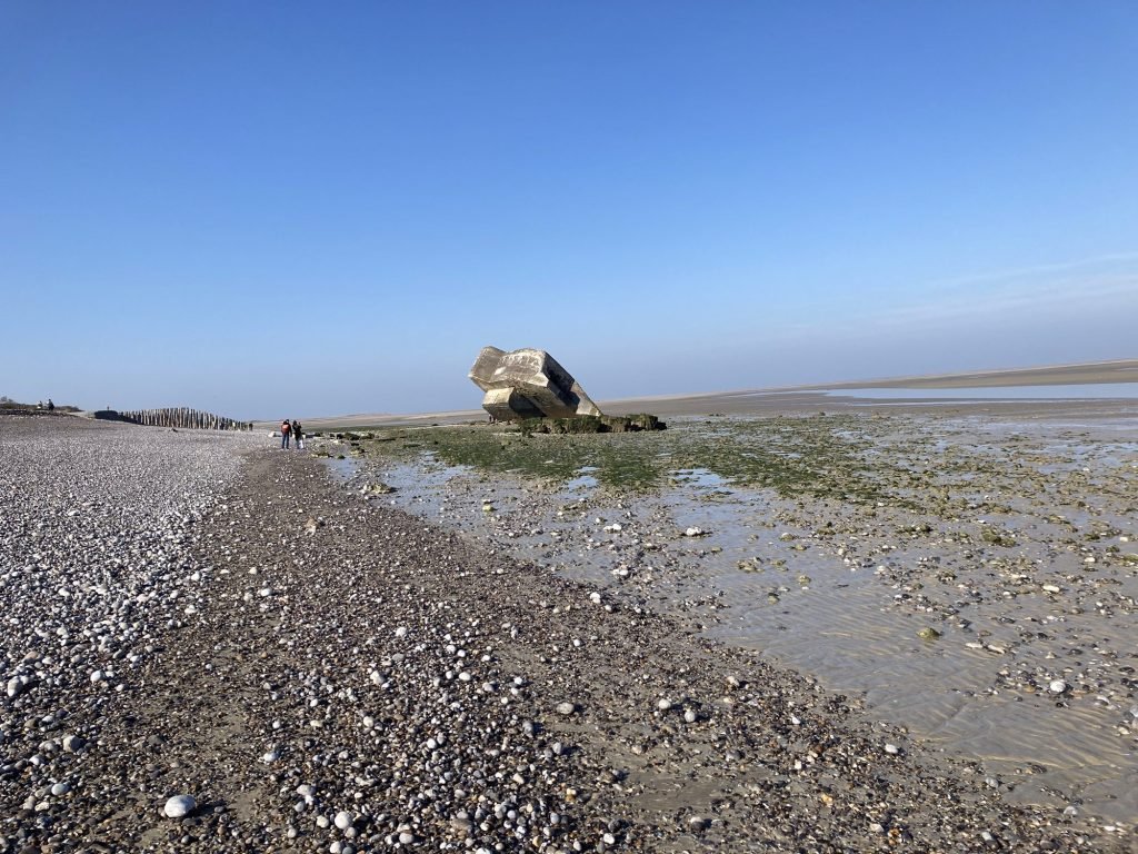 Oude Duitse bunker op keienstrand bij eb
