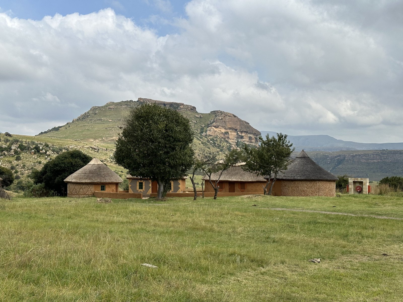 Basotho Cultural Village: traditionele hutten met berg op achtergrond. 