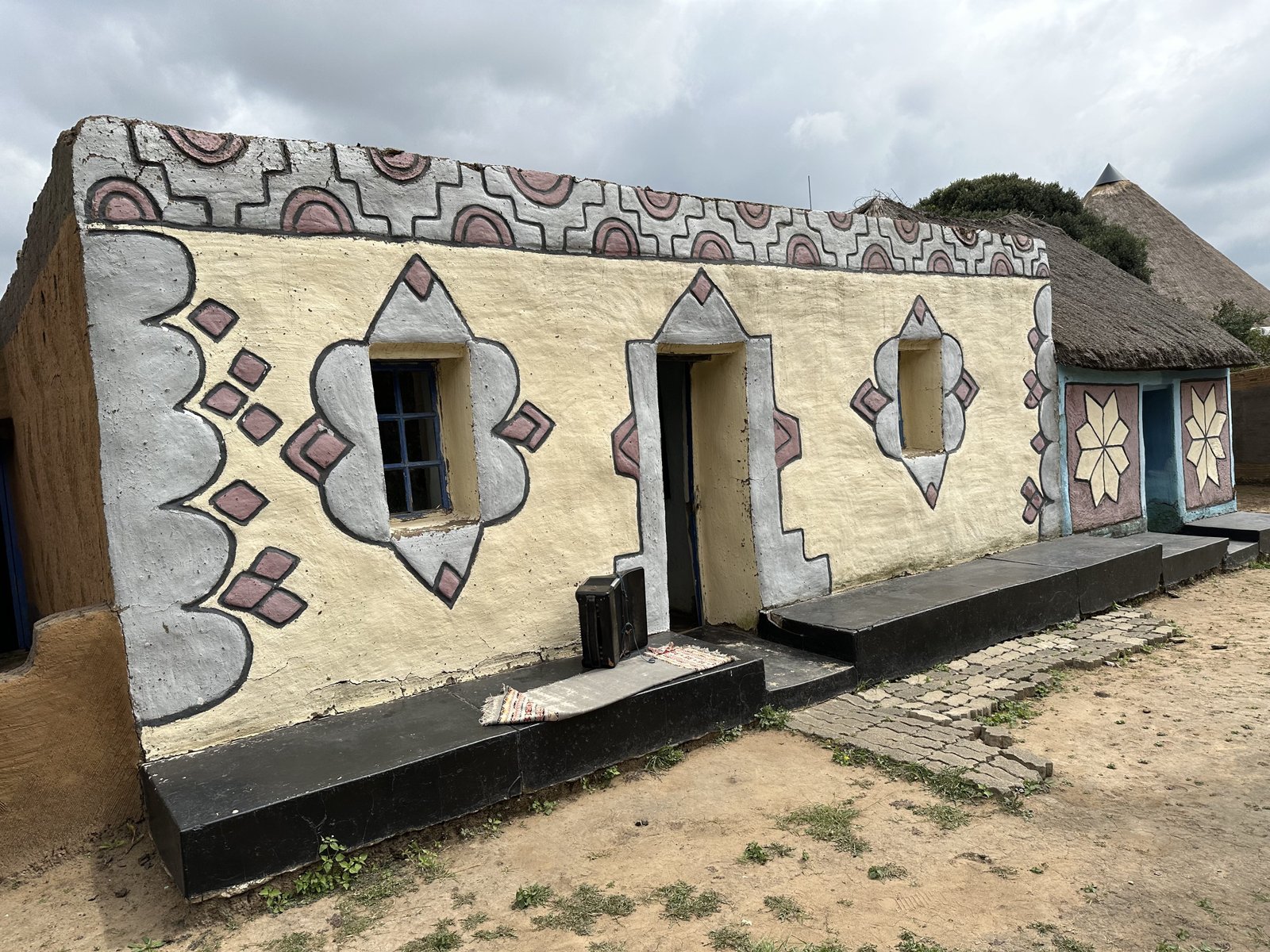 Basotho Cultural Village: huis met beschilderde muren. 