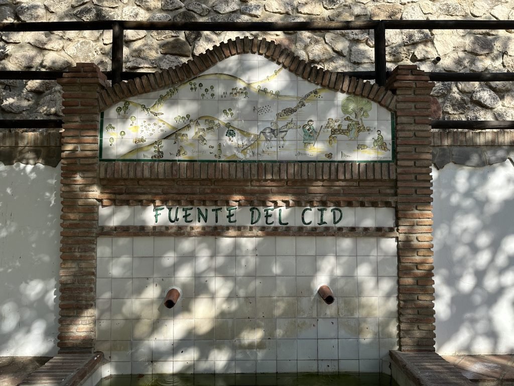 Fuente del Cid​: twee roestige waterpijpjes uit een wit-betegelde wand. 
