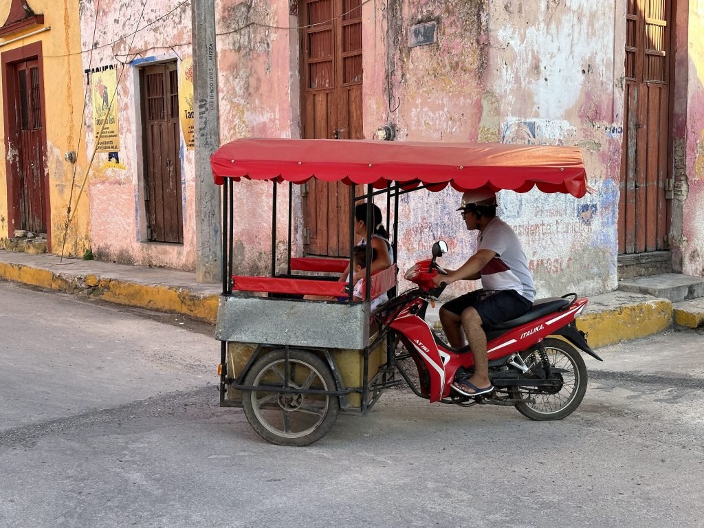 Rode driewieler taxi voor rood hoekhuis. 