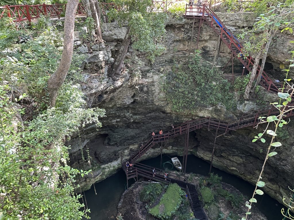 Chichikan cenote: houten trappen leiden naar de vloer van de cenote. 