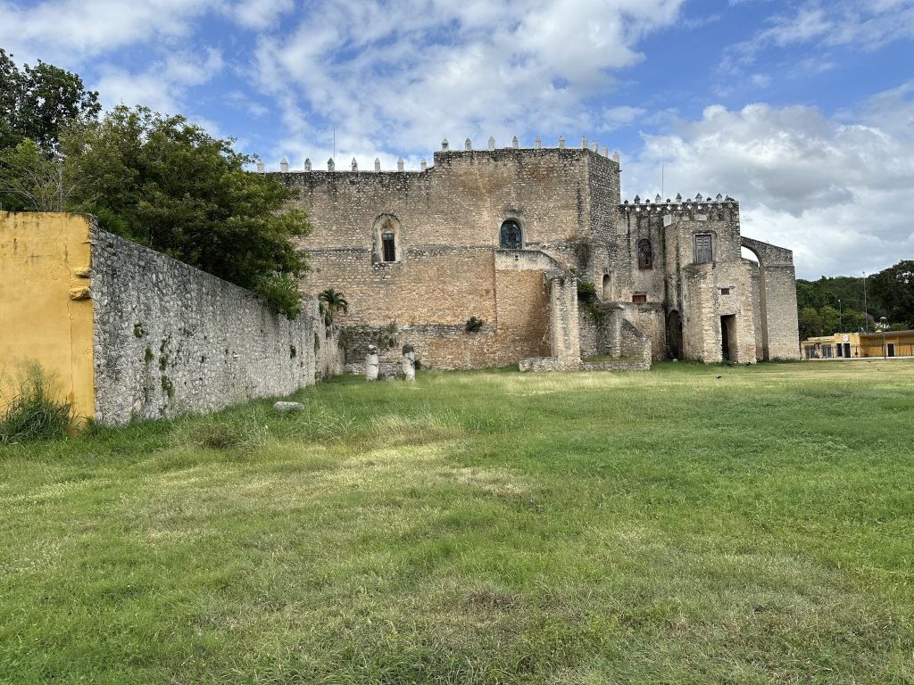 Grasveld met grijze buitenmuren van het Convento de San Antonio de Padua. 