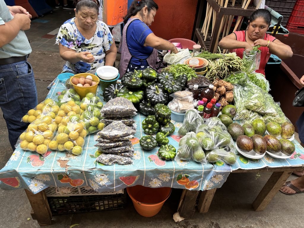 Groentenkraam met drie vrouwen op de markt van Campeche. 