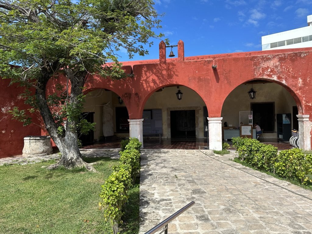 Museo de Arquitectura Maya: rood gebouw met bogen. 