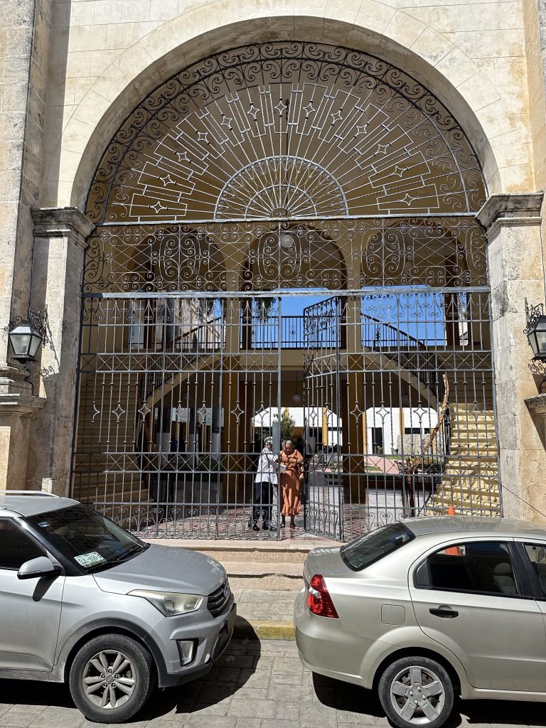 Groot ijzeren hek onder boog leidend naar de kerk van San Roque in Campeche. 