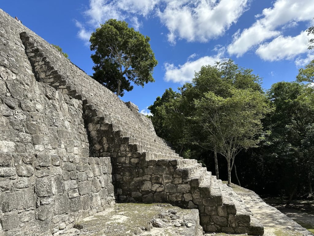 Stijle trappen van piramide in Calakmul naast bomen 