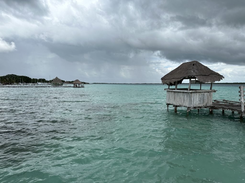 Bluw-groene lagune van Bacalar met hutje op pier rechts.