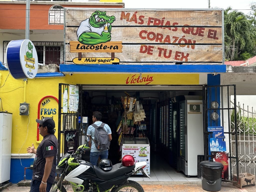 Mini-supermarkt met grappige en schreeuwerige reclamebord in Bacalar