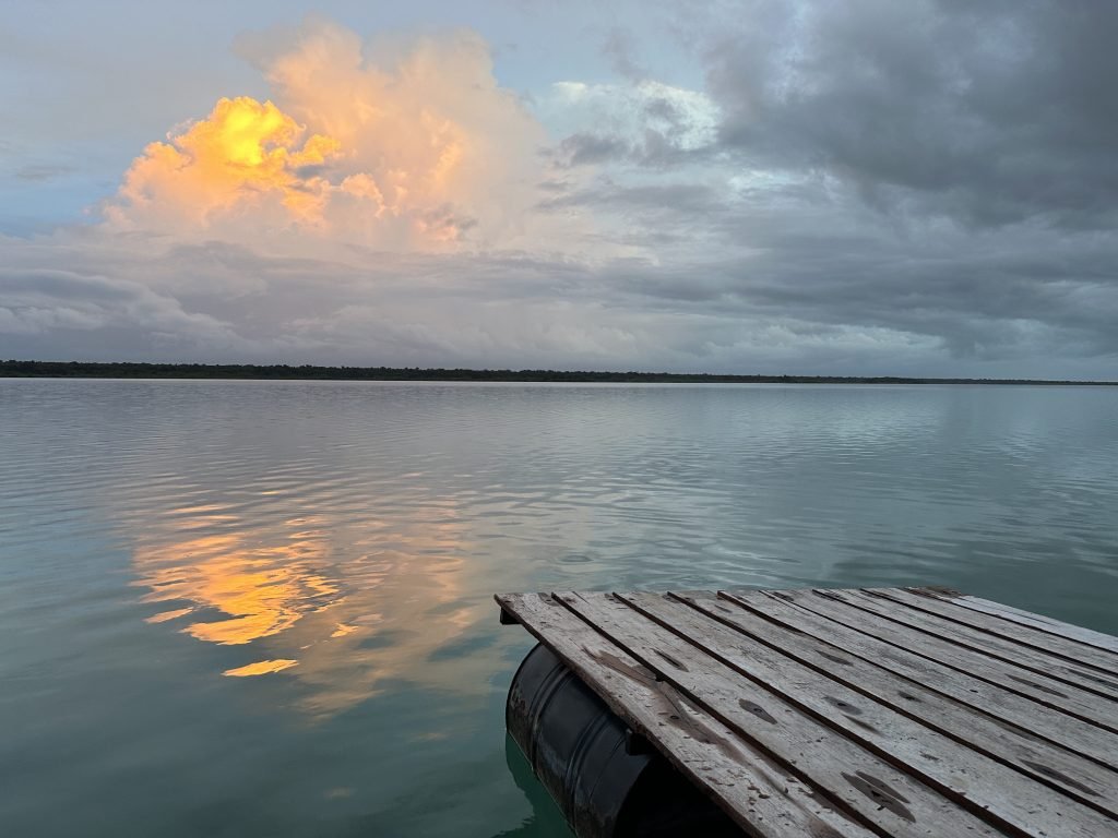 Ondergaande zon en wolken over de lagune van Bacalar. 